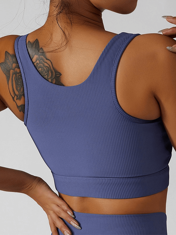 Woman wearing a stylish elastic sports cropped top in breathable nylon, featuring a sleeveless design; ideal for yoga with quick-dry fabric.